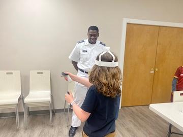 James Bangura ’26 guides a student learning a virtual reality headset at the Rockbridge Regional Library.