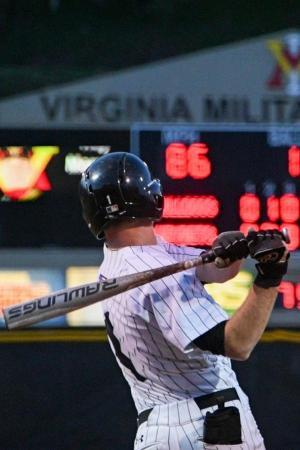 Cadet portrait after swinging bat with scoreboard in the background