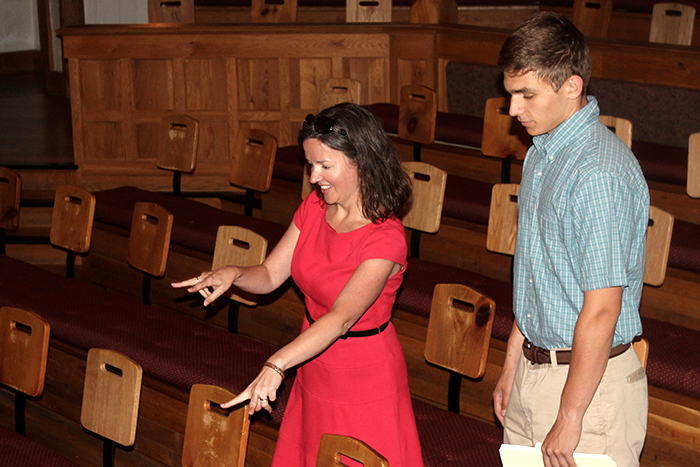 A woman is pointing at a chair while a student stands by