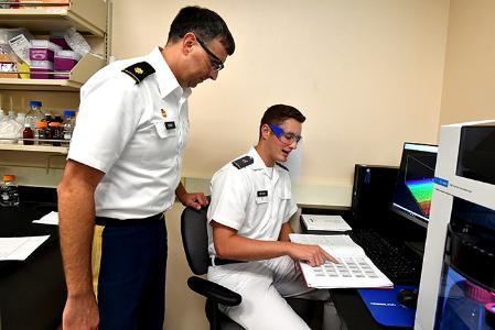 Maj. Kevin Braun and Tom Wiltshire ’22 discuss Wiltshire’s forensic analysis of pen inks.