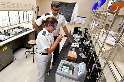 Maj. Kevin Braun watches as Noelle Heilpern ’23 prepares a pottery sherd for analysis