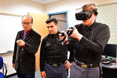Two cadets and professor demonstrate virtual reality equipment