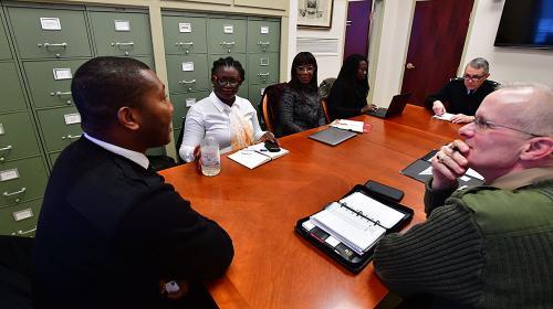 Three faculty members talk with three Aseshi University members