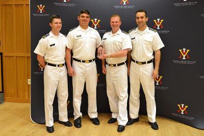 Four cadets stand with an award