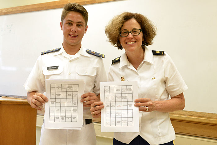 A professor and cadet stand with a piece of paper