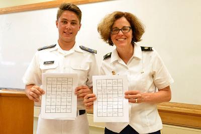 A professor and cadet stand with a piece of paper