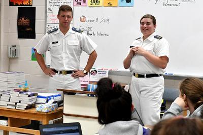 Kirk Ring ’21 and Grace McDonald ’21 are shown addressing students in a classroom.