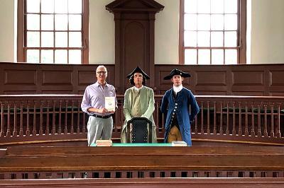 Col. Turk McCleskey, professor of history, poses with historical interpreters at the Williamsburg Courthouse.