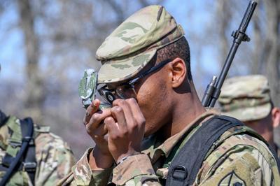 VMI Naval ROTC Marine Option cadets stand at attention wearing camouflage uniforms outside VMI building