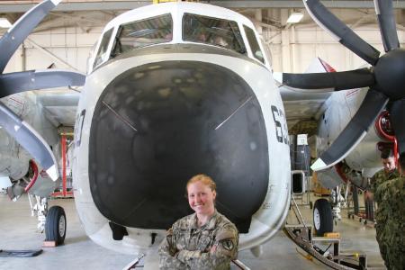 Female NROTC Cadet in front of plane during an aviation tour