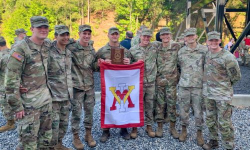 Eight rising 2nd Class VMI Army ROTC cadets pose with flag after completing Air Assault School training at Ft. Benning, Georgia. Photo provided by Bryson Minear ’24