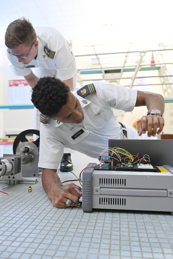 Two students (cadets) in the Department of Mechanical Engineering set up equipment at the VMI pool for an experiment.