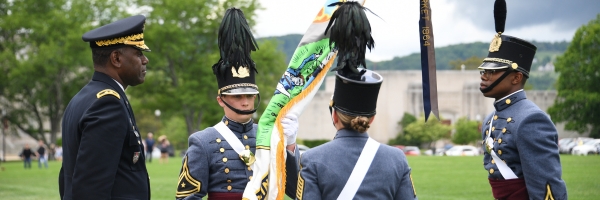 Leaders of the VMI Corps of Cadets pass flags during ceremony with superintendent, representing the change in cadet leadership.