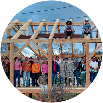 Timber Framers Club cadet members group standing and sitting in timber frame building under construction photo circle