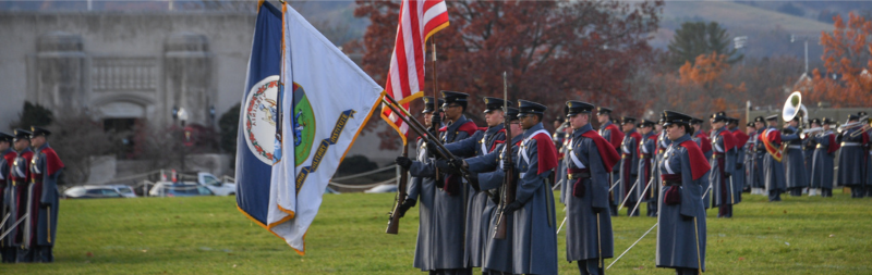VMI cadets hold state and national flags during a parade.