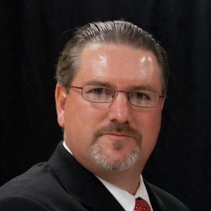 Profile image of Chris Spence with glasses and suit