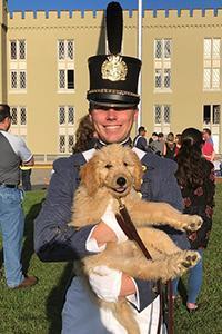 Will Nicholson in parade outfit holding a puppy