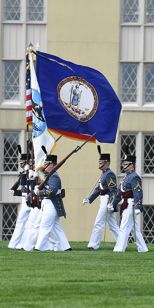 VMI cadets march with national and state flags.