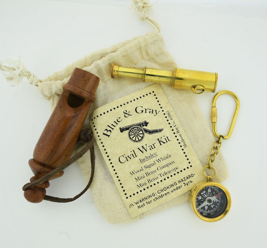 a muslin 4 x 5 inch bag with a wood whistle, brass mini compass keychain and brass expanding telescope necklace
