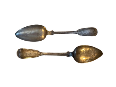 Flat silver spoons with tapered ends.