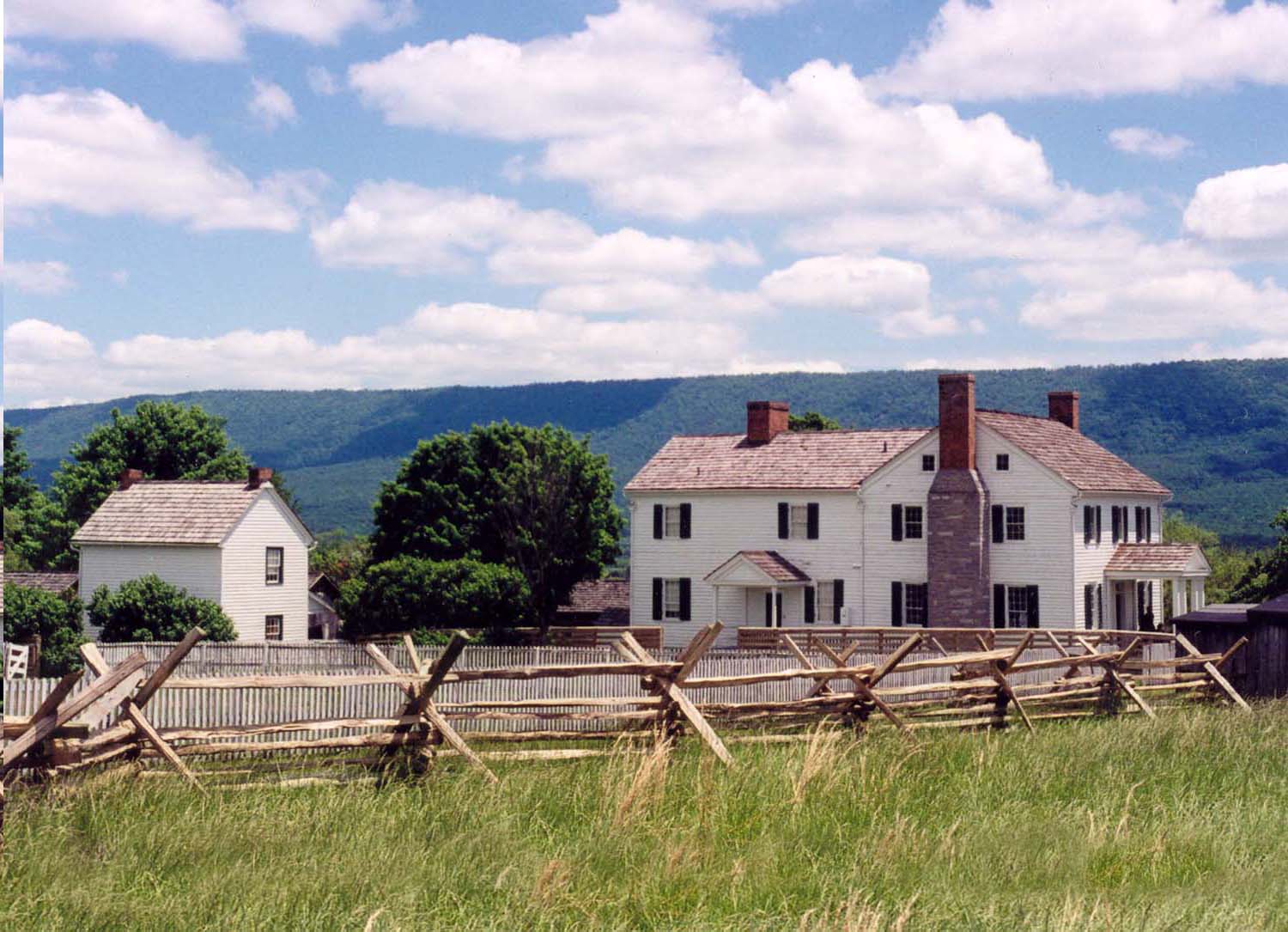 Photo of Bushong Farmhouse with rail fence in foreground