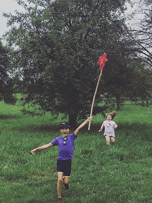 Child flying a kite during summer camp