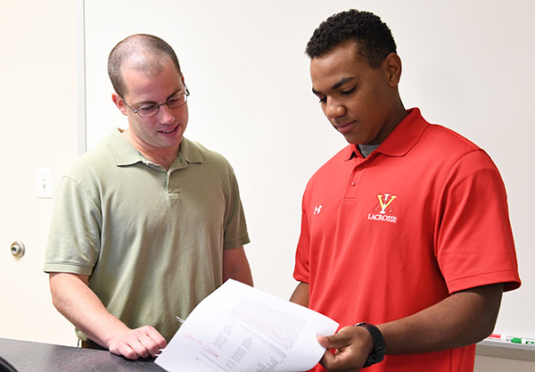 Maj. John David and Christian Helms looking at papers