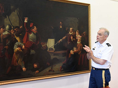 Col. Keith Gibson stands next to the painting 