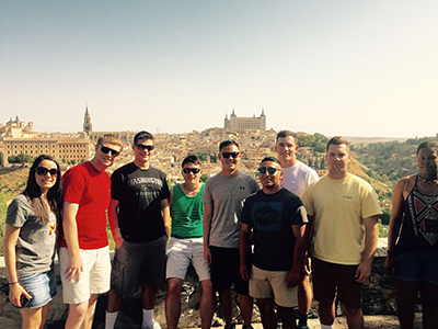 A group of cadets stand before the Toledo, Spain, skyline.