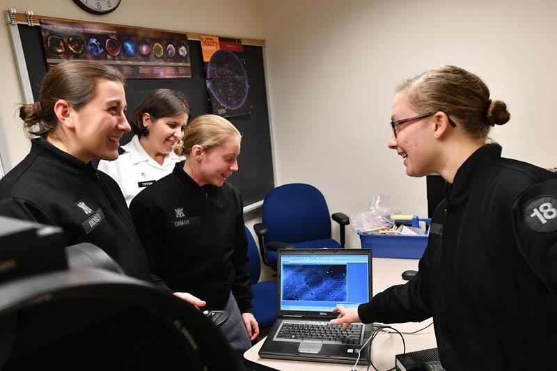 Julianne Knoblett ’20, Eryn Daman ’18, and Marlene Haag ’18, each members of WiSE, look at an image taken by a telescope with Col. Daniela Topasna, professor of physics and astronomy. – VMI Photo by H. Lockwood McLaughlin. 