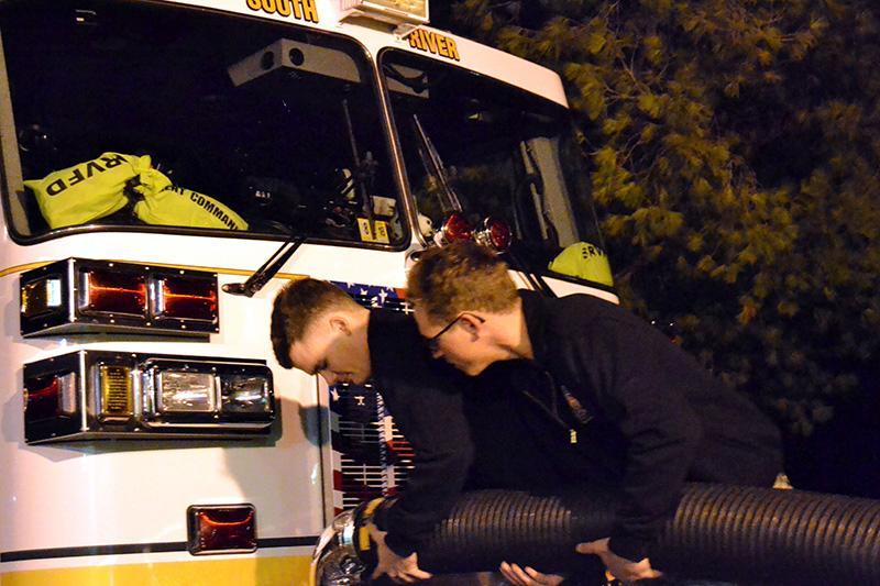 Ian Morris ‘19 (left) and Zach Thoele ‘19 adjust a coupling on a tanker truck during an evening shift at the South River Volunteer Fire Department.