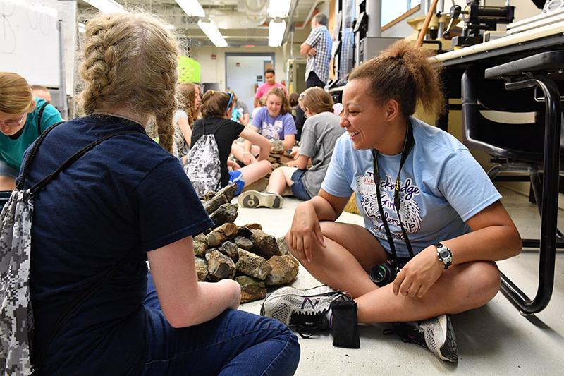 Annika Tice builds rock sculptures with middle school girls.