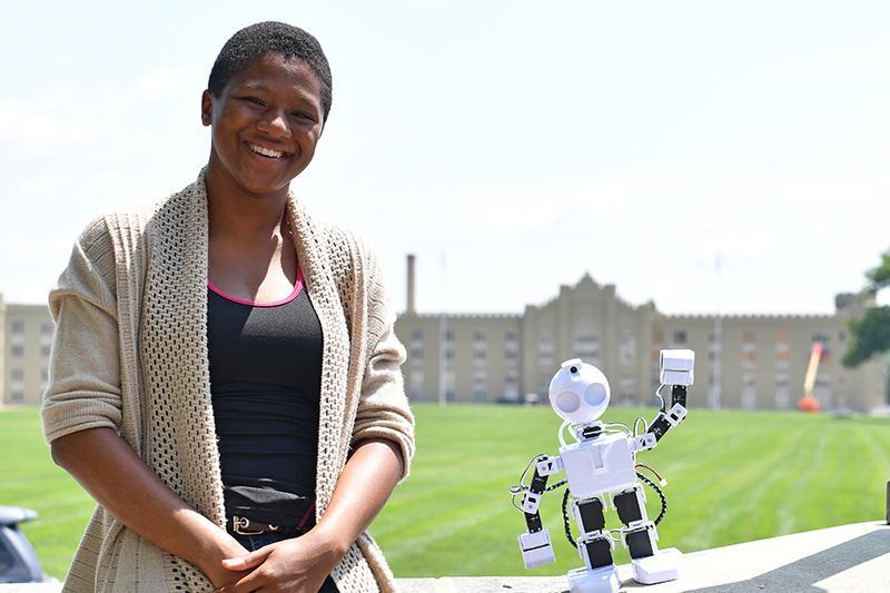 Miyah Boyd pauses with her robot on the porch of Moody Hall.—VMI Photo by H. Lockwood McLaughlin.