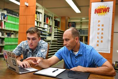 Tristan Howard ’20 and Col. Barry Cobb discuss Howard’s research on staffing needs for healthcare.—VMI Photo by Mary Price.