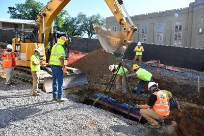 Construction workers place Col. Claudius Crozet, first president of the VMI Board of Visitors, in his final resting place seven feet from his previous resting place on Friday morning.—VMI Photo by Kelly Nye.