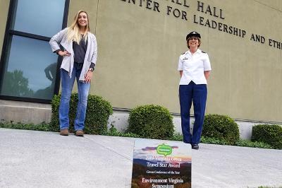 Emily Coleman and Kim Connolly stand behind an plaque