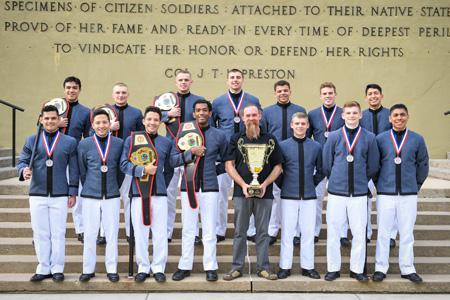 The VMI Regulators club boxing team posing for photo in uniforms holding national champion trophies from the United States Intercollegiate Boxing Association National Championships