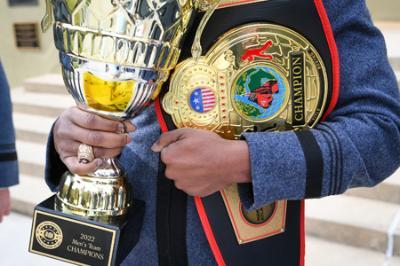 A member of the The VMI Regulators club boxing team holds national champion trophy and belt from the United States Intercollegiate Boxing Association National Championships