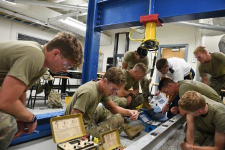 Cadets in Col. Matt Swenty’s civil engineering lab set up gauges before stress testing an aluminum I-beam.—VMI Photo by Mary Price.