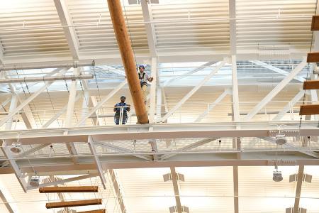 A COW participant gets encouragement from a friend as he crosses the indoor high ropes course in the VMI Corps Physical Training Facility.—VMI Photo by Marianne Hause.