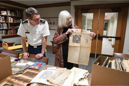 Lisa Tracy shows Maj. Jeff Kozak a copy of the Baltimore Sun from May 1963 featuring Maj. Gen. Charles E. Kilbourne, VMI Class of 1894, meeting President John F. Kennedy.—VMI Photo by Kelly Nye.