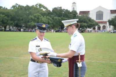 Kasey Meredith ’22 and Kathryn Christmas, Citadel regimental commander, exchange momento covers at the Citadel.—VMI Photo by Eric Moore.