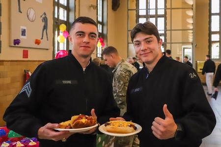 Two students, known as cadets, at VMI enjoy a hot dog event in Crozet Hall celebrating MLB opening day.