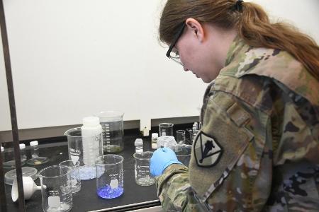 Maj. Shannon Quevedo, assistant professor in the chemistry department at Virginia Military Institute, examines hydrogels in researching ways to detect contaminates in water. -VMI Photo by Marianne Hause.