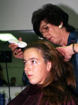 Brooke Green ’01 receives a buzz cut from Connie Hostetter in the VMI Barber Shop Aug. 19, 1997.—Photo courtesy of VMI Archives.