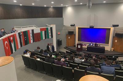 Riley Shultz ’24, Christian Cole ’24, and Parker Rice ’24 confer on debate strategy in the balcony overlooking the assembly at the Model Arab League.-Photo courtesy of Maj. Jason Schroepfer.