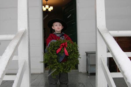 A young boy holds a wreath at the Bushong Farm Christmas event.