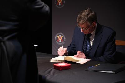 Robert Child signs a copy of his book following his presentation.