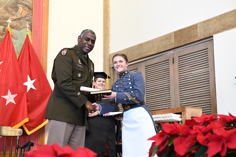 Superintendent Maj. Gen. Cedric T. Wins '85 congratulates a female graduate of Virginia Military Institute as he hands her her diploma during the December 2023 commencement ceremony.