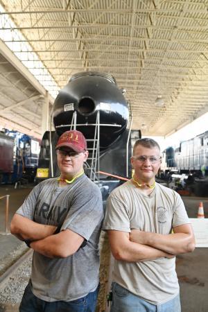 Ryan and Andrew Quesenberry ’26 pause after a hot morning working on the 611.